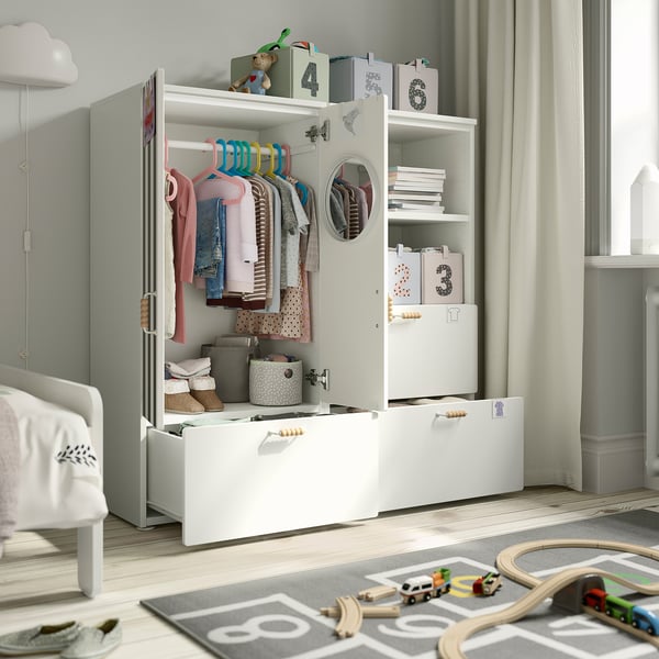 Childs room with a white wardrobe organized with clothes, books, and toys. Shelves, drawers, and hangers for easy child access.