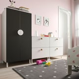 Kids room with black & white SMÅSTAD wardrobe & drawers, polka-dot rug, toys on floor.