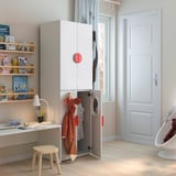 Childrens room with white SMÅSTAD wardrobe, desk, and shelves. Wardrobe has open doors, revealing clothes. Shelves hold books and toys.