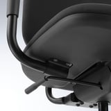 Black office chair detail: sleek backrest, adjustable armrest, castors.