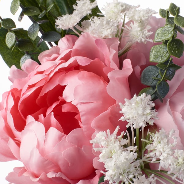 Close-up of vibrant, fake bouquet; large pink peonies with white fillers, green leaves; detailed textures and realistic.