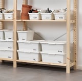 Wooden shelf storage with white boxes labeled seeds, tools, games, and bulbs. Boxes have snap-on lids for dust protection and stackable design.