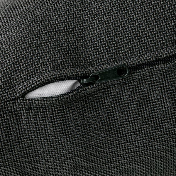 Close-up of a zipper on a high-quality, textured fabric sofa. The metal zipper is partially open, revealing inner lining.
