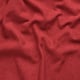 Close-up of rich, textured, red fabric with subtle melange effect, showcasing its soft and high-quality appearance.