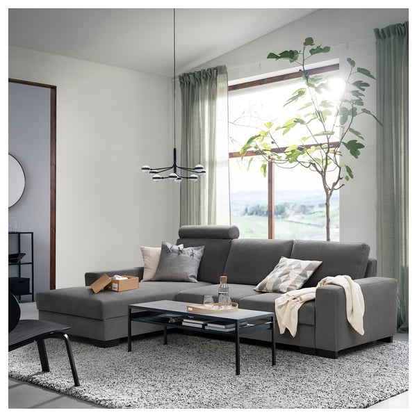 Modern living room with SÖRVALLEN gray sectional sofa, coffee table, large window, curtains, plant.