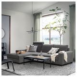 Modern living room with SÖRVALLEN gray sectional sofa, coffee table, large window, curtains, plant.