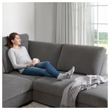 Woman relaxes on SÖRVALLEN sofa with mug, blanket nearby.