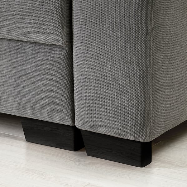 A modern sofas corner, upholstered in gray fabric, with sleek black wooden legs.