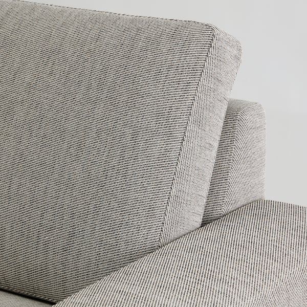 Close-up of a modern couch, SÖRVALLEN, in neutral tones. Textured fabric and angled backrest visible.