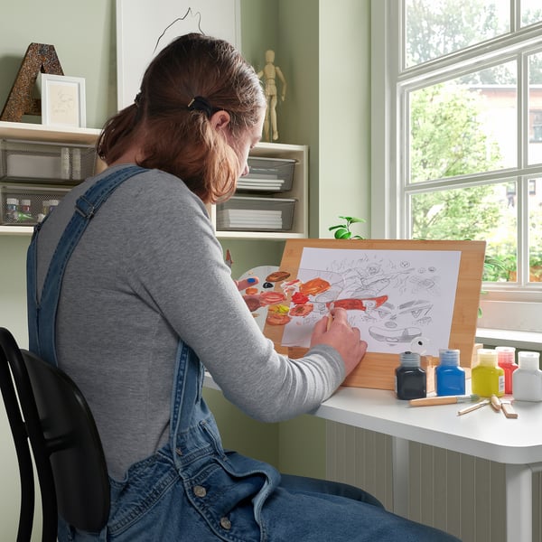 Person painting with acrylics on SOLFÅGEL easel.