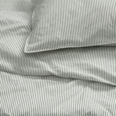A stack of green striped bedding: 2 pillows and a flat sheet, all made of eco-friendly cotton.