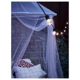 A cozy indoor hammock tent, SOLIG, illuminated by warm string lights, providing a relaxing space.
