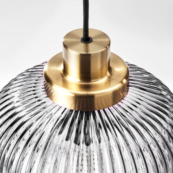A modern pendant lamp showcasing a textured, grey glass shade with a sleek gold-colored metal holder.