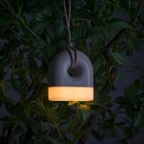 Hangable lamp emits warm light, perfect for outdoor use, no cables needed.