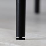 Black metal table leg with rounded base, standing on light wooden floor.