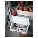 Open plastic storage bin filled with papers, used for organizing documents. Positioned on a shelf next to jars of preserved food and bottles.