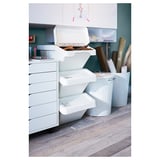 Stacked white SORTERA storage bins with foldable lids in an organized workspace.
