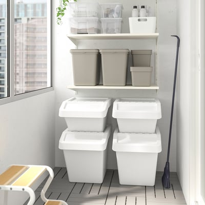 SORTERA bins stacked, some on shelves, others on floor, with a broom.