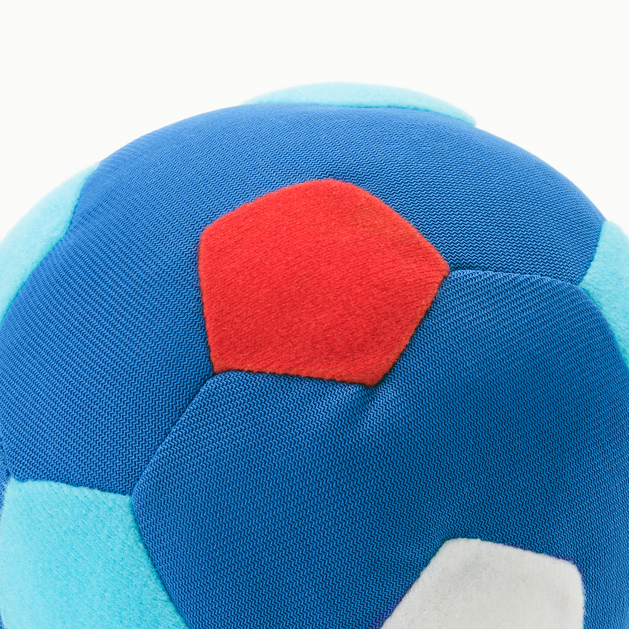 Soft, multicolored ball close-up, mostly blue, red, and light blue with white logo, surface looks durable and child-safe.