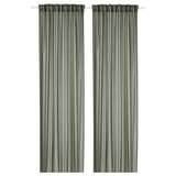 Two green STENFRÖ sheer curtains hang straight, offering a sense of calm. Made from recycled polyester, they diffuse sunlight, adding privacy.