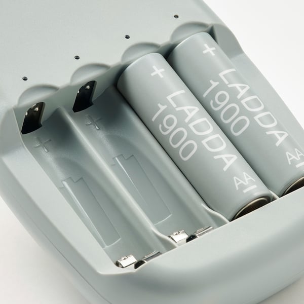 Close-up of four ladda rechargeable batteries in STENKOL charger, showcasing quality and branding.