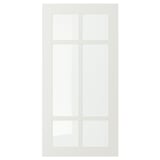 A white STENSUND cabinet door with a glass panel divided into four sections by wooden frames, designed for kitchen use.