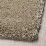 Soft, light-colored shaggy rug laid on wooden floor, showcasing its thick, cozy texture.