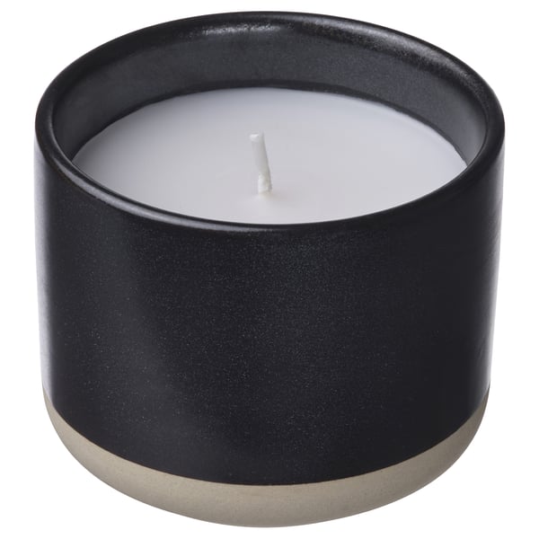 Black ceramic STÖRTSKÖN candle, round shape, white wax, cotton wick.