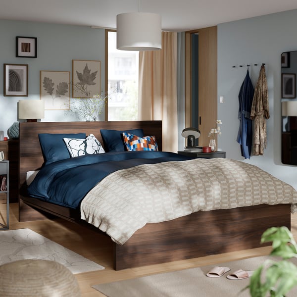 Modern bedroom with STORKLINTA bed, wood finish, blue bedding, window, nightstands, and cosy decor.