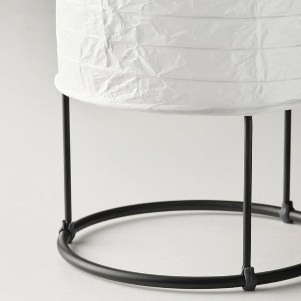 Black metal-framed table lamp with white rice paper shade, showcasing modern design and soft diffused lighting.