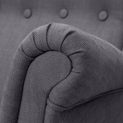 Close-up of high-quality, gray tweed fabric on a upholstered sofa armrest, showcasing its texture and detail.