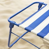 Folded striped beach chair, durable & portable.