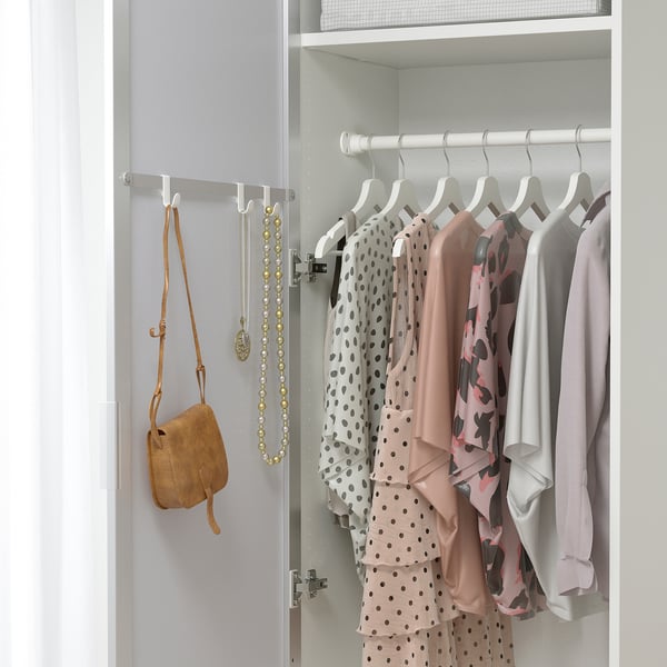 Open closet with clothes. Mirrored door reflects hanging garments.
