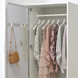 A wardrobe with mirrored door reflecting clothes and accessories, saving space and providing convenience for dressing.