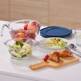 Fruit bowl, salad bowl & plate on counter with croissants and utensils.