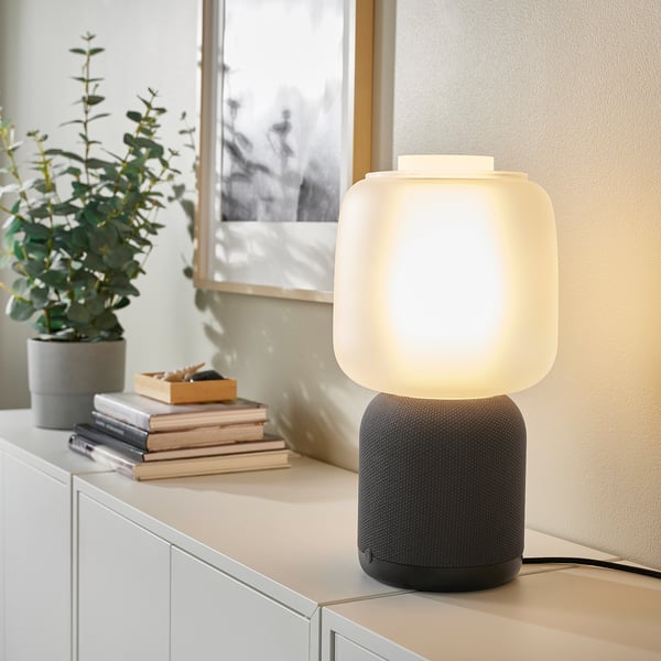 SYMFONISK wifi speaker lamp on shelf with plant, books, frame.