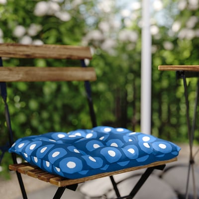 Blue patterned outdoor chair cushion on wooden chair.