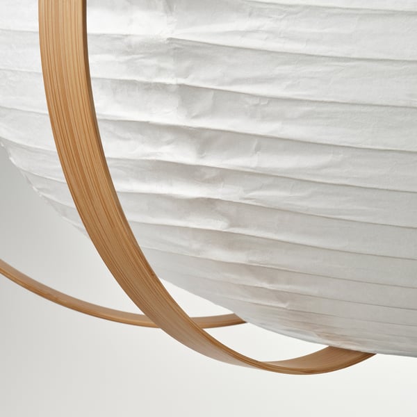 Description: modern, circular pendant lamp with sleek bamboo ribs holding a soft, white rice paper shade, casting a gentle glow.