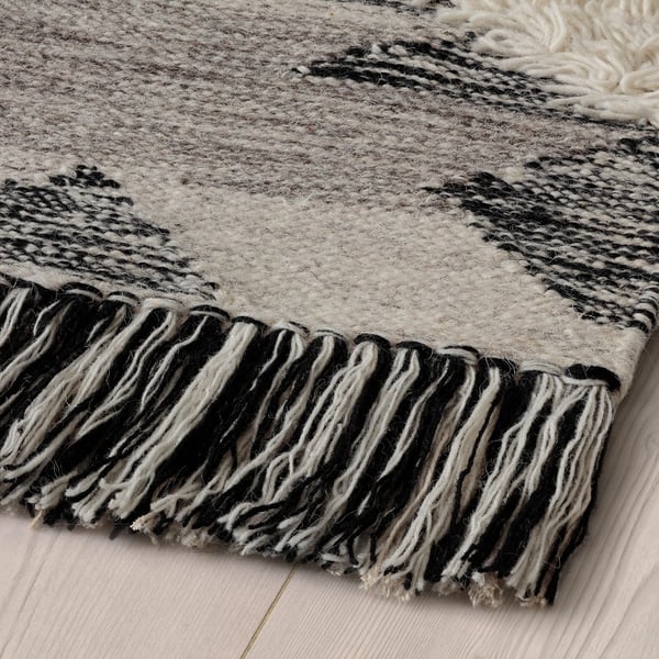 Black and white striped rug with fringe, handmade, wool and cotton, high texture, durable, traditional design.
