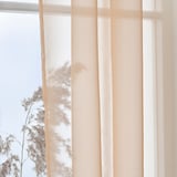 Sheer striped curtains let soft light in, balancing privacy and openness to nature.