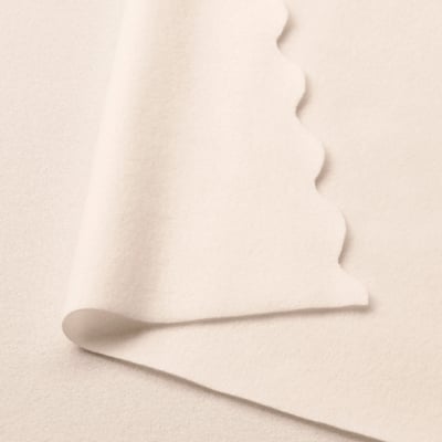 Folded off-white fleece blanket, soft & warm, made from recycled polyester.