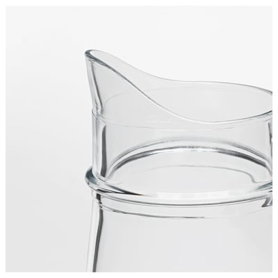 Clear glass jug with a handle, designed for serving beverages or holding flowers.