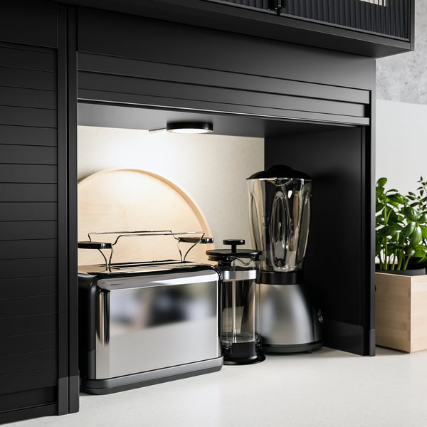 Modern kitchen with black TITTEBO storage, hiding appliances. Sleek, metallic, and stylish design.