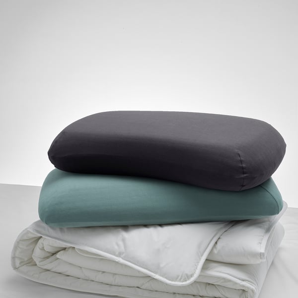 Three pillows stacked: grey, teal, white. Greys larger, elastic design.