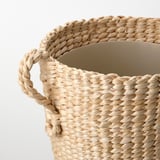 Hand-woven natural fiber basket with sturdy handles, showcasing intricate textures and craftsmanship.