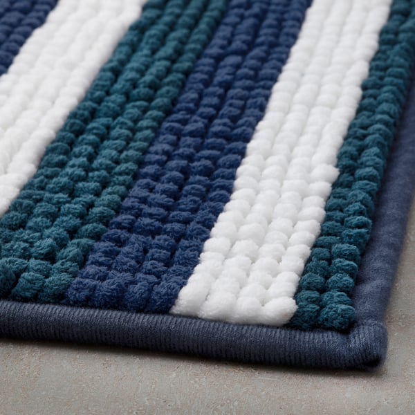 Striped bath mat, soft & absorbent, blue & white colors.