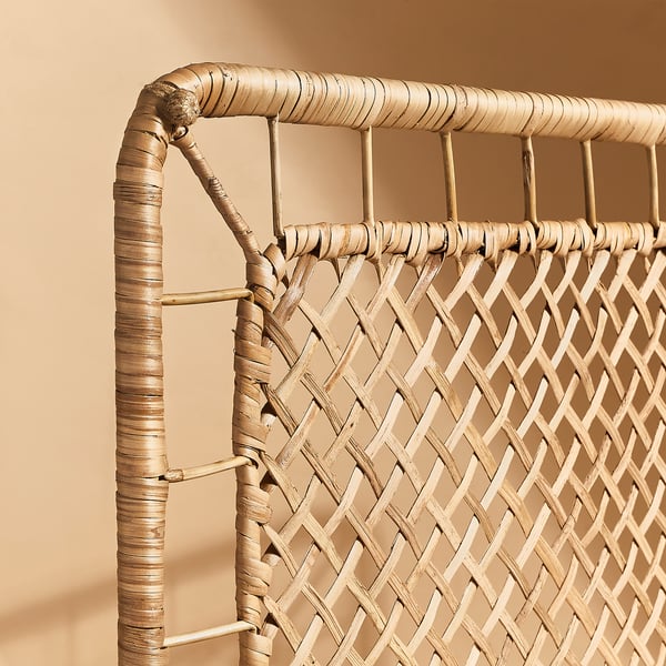 Woven rattan headboard corner detail. Shows intricate craftsmanship with natural fibers.