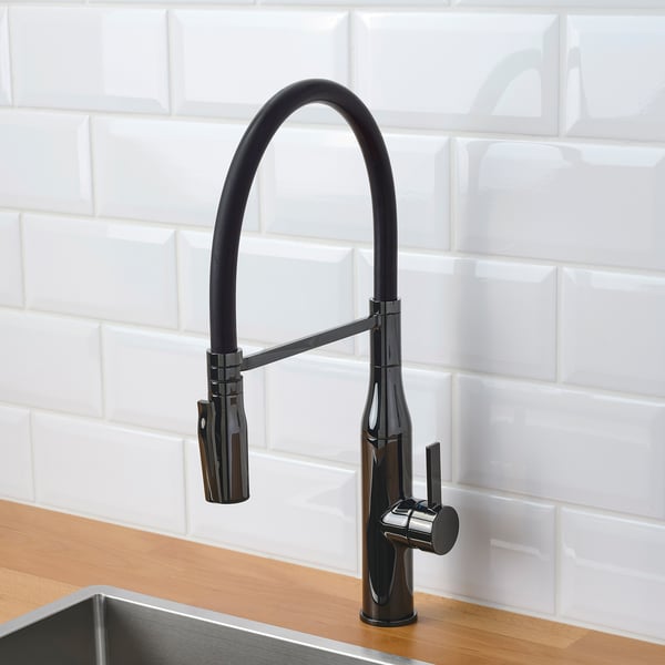 Black kitchen faucet with pull-down sprayer on wood countertop.