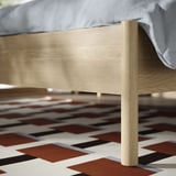 Modern wooden bed, light wood finish, clean lines, sturdy legs, under-bed storage space.