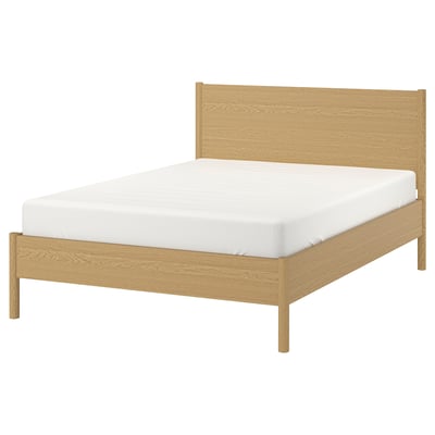 A TONSTAD bed with a light oak finish, featuring a clean, minimalist design with a rectangular headboard and adjustable bed sides.